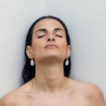 Model wearing gold earrings with fresh water baroque pearls
