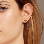 Gold earrings pair with baguette cut citrine and pink tourmaline worn by woman