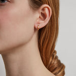 Model wearing a mini gold hoop earring