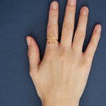 House shaped gold ring with small diamond on woman's hand