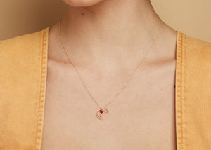 Gold chain necklace with croissant shaped pendant hand-painted in raspberry enamel worn by model