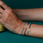 Burgundy cord bracelet with cat shaped pendant worn by model