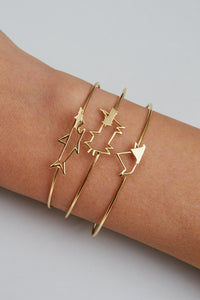 Gold bangle bracelet with cat shaped clasp on model's hand