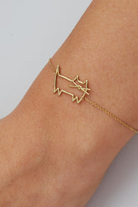 Gold chain bracelet with cat shaped pendant worn by model