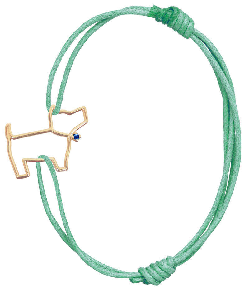 Bottle green cord bracelet with a little dog shaped gold pendant with a blue sapphire