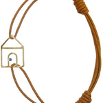 Brown cord bracelet with gold house shaped pendant and small blue sapphire