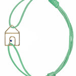 Mint green cord bracelet with gold house shaped pendant and small blue sapphire