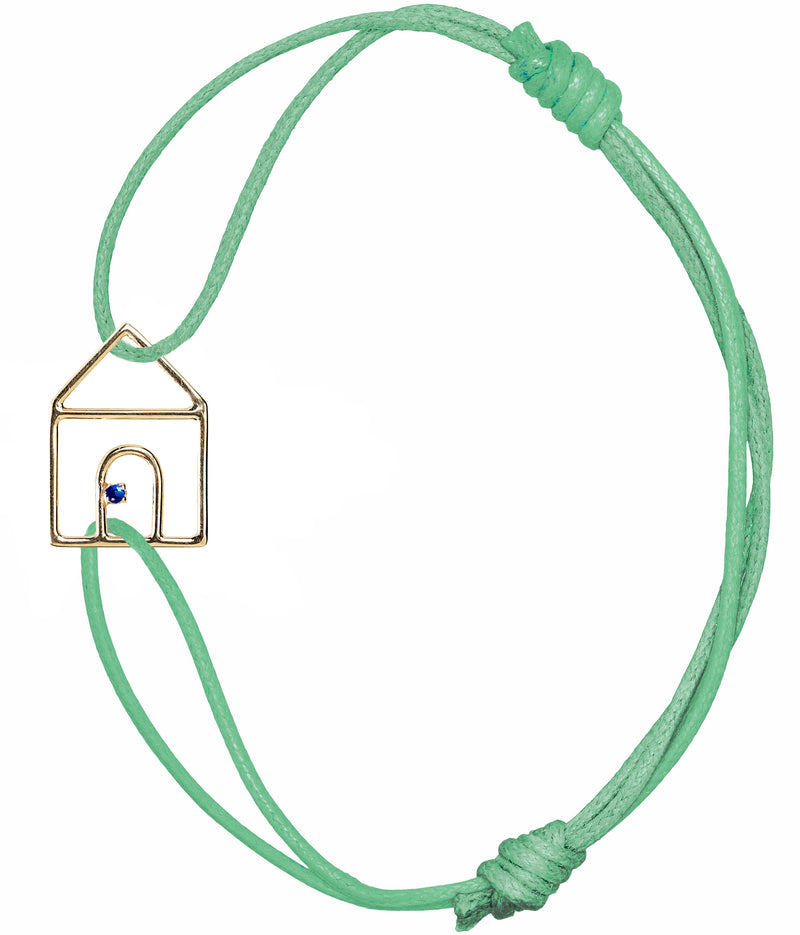 Mint green cord bracelet with gold house shaped pendant and small blue sapphire