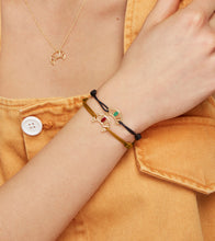 Load image into Gallery viewer, Brown cord bracelet with gold croissant shaped pendant hand-painted in raspberry enamel worn by model
