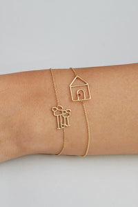 Gold chain bracelets with a house shaped pendant with a small ruby stone