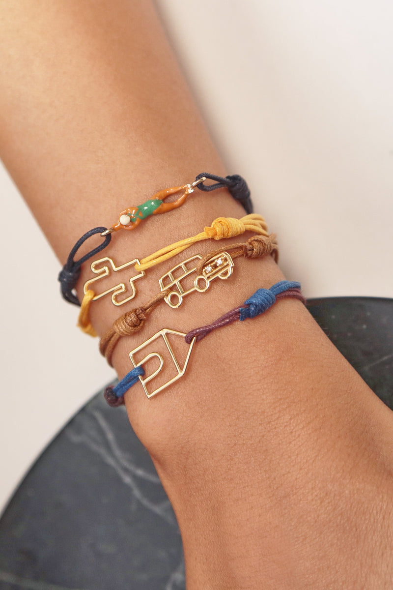 Cord bracelets with gold pendants shaped like house, cactus, jeep car worn by model