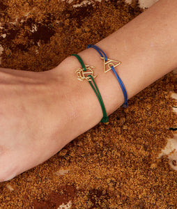 Blue cord bracelet with gold indian tent shaped pendanr worn by model