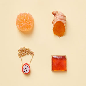 Composition with dragon fruit coral necklace and orange food