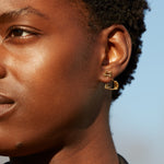 Seated cat shaped earring worn by woman