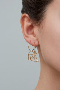 Gold earring circles with house and rabbit shaped pendants worn by model