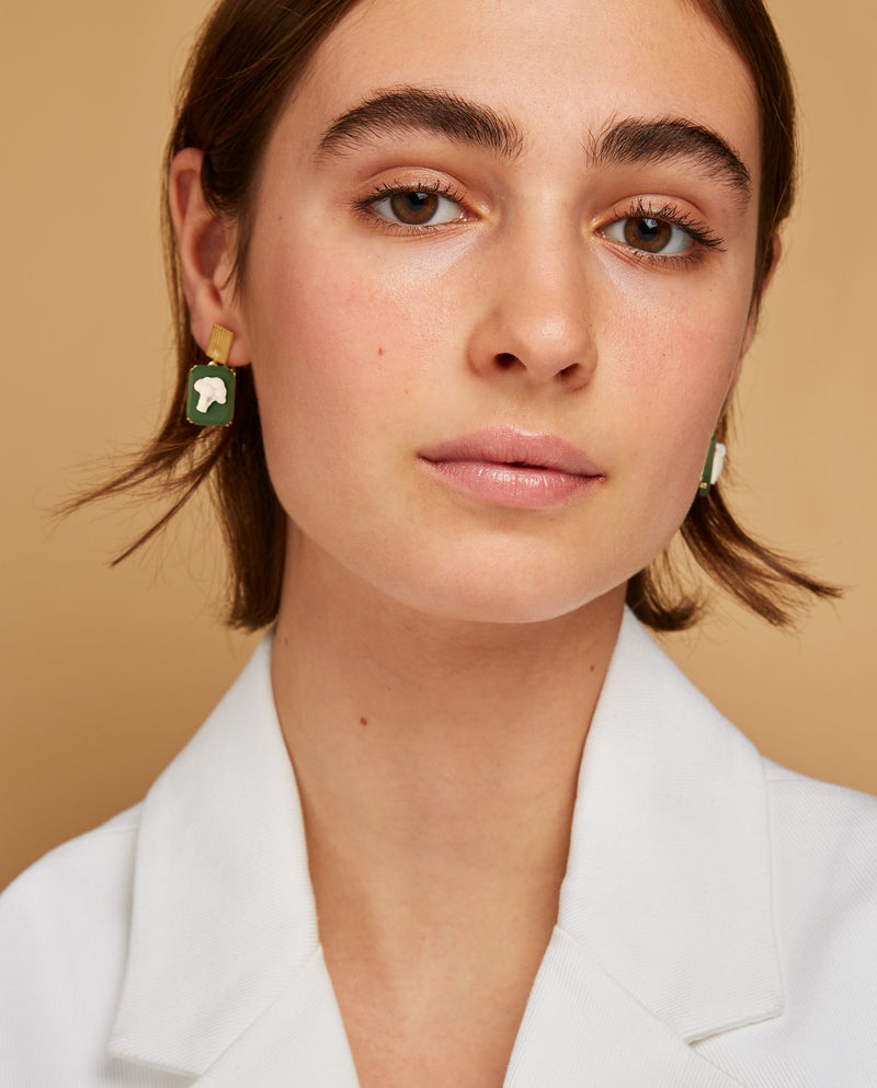 Model wearing gold earrings with broccoli shaped cameo in green porcelain