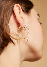 Load image into Gallery viewer, Gold scarab beetle shaped maxi earring with small blue sapphires worn by model
