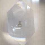 Gold chain necklace with chemistry baker shaped pendant under lens