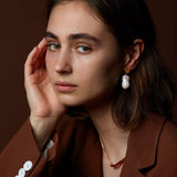 Model wearing gold earring with fresh water baroque pearl