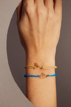 Load image into Gallery viewer, Bright blue eco cord bracelet with a little boat shaped gold pendant on woman&#39;s wrist
