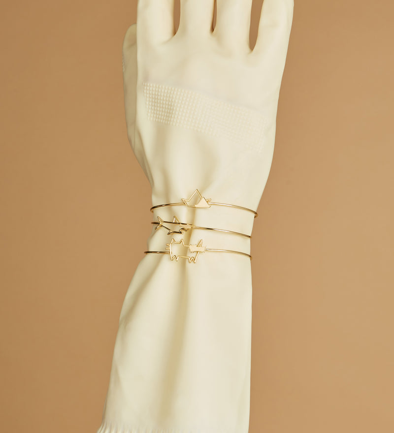 Gold bangle bracelets on hand with glove