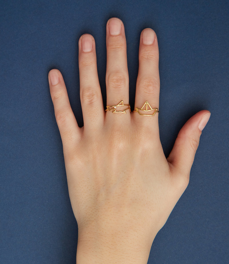 Gold shark shaped ring with small diamond eye worn by model