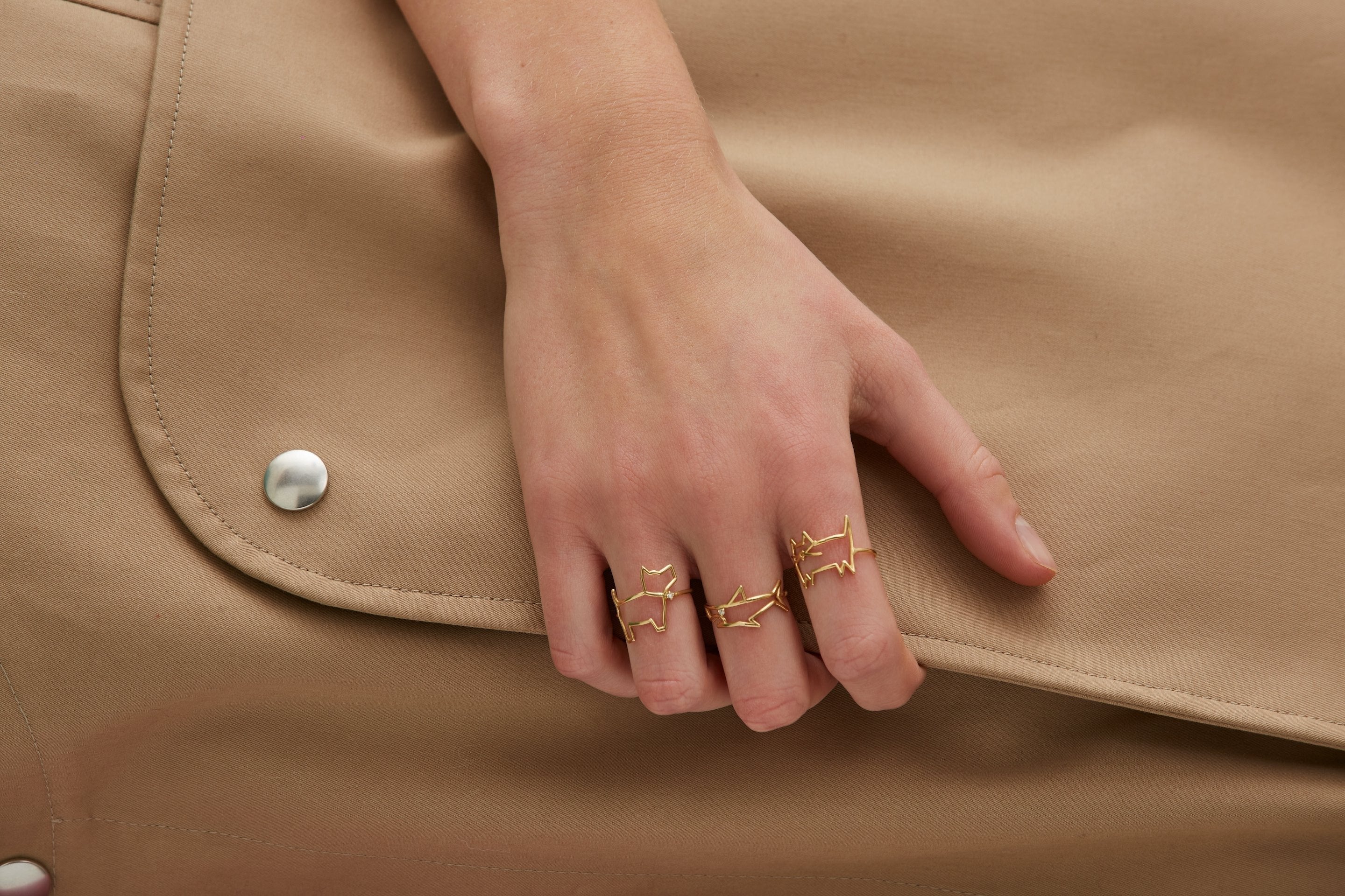 Gold dog shaped ring and small diamond worn by model