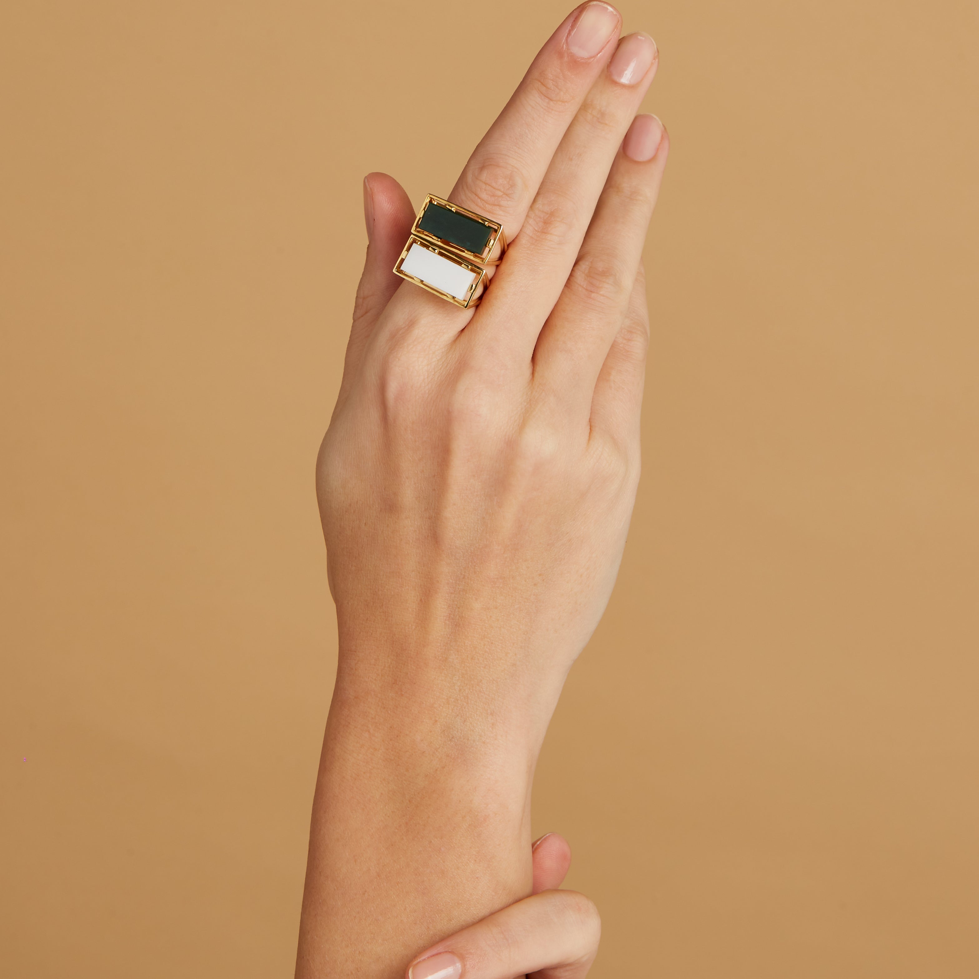 Gold square rings with jasper stone and white agate on woman's hand