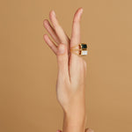 Gold square rings with white agate and jasper stones on woman's hand