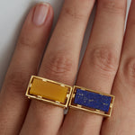 Gold square ring with lapis lazuli stone and yellow jade on woman's hand