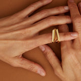 Gold ring with triangular cut citrine stone on model's hand