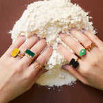 Hands dipped in flour wearing gold rings with precious stones 