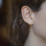 Mini gold hoop earrings worn by model