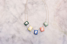 Load image into Gallery viewer, Gold chain necklace with multiple colored porcelai cameo pendants on marble table
