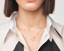 Load image into Gallery viewer, Woman wearing a gold chain necklace with a little dog shaped pendant with a blue sapphire
