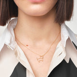 Model wearing gold chain necklace with small dog shaped pendant