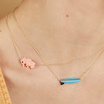 Gold chain necklace wih surf shaped turquoise pendant on model