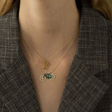 Model wearing gold chain necklaces with family and bike shaped pendants