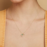 Gold chain necklace with croissant shaped pendant hand-painted in pistachio enamel worn by model