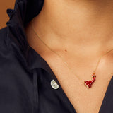 Gold chain necklace with flamenco dancer shaped pendant in red enamel worn by model