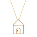 Gold chain necklace with house shaped pendant and small emerald
