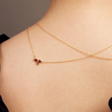 Gold rolo chain necklace with a baguett cut citrine and a baguette cut pink tourmaline on woman