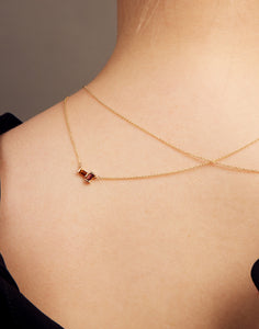 Gold rolo chain necklace with a baguett cut citrine and a baguette cut pink tourmaline on woman