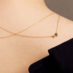 Gold rolo chain necklace with a baguett cut citrine and a baguette cut pink tourmaline on woman