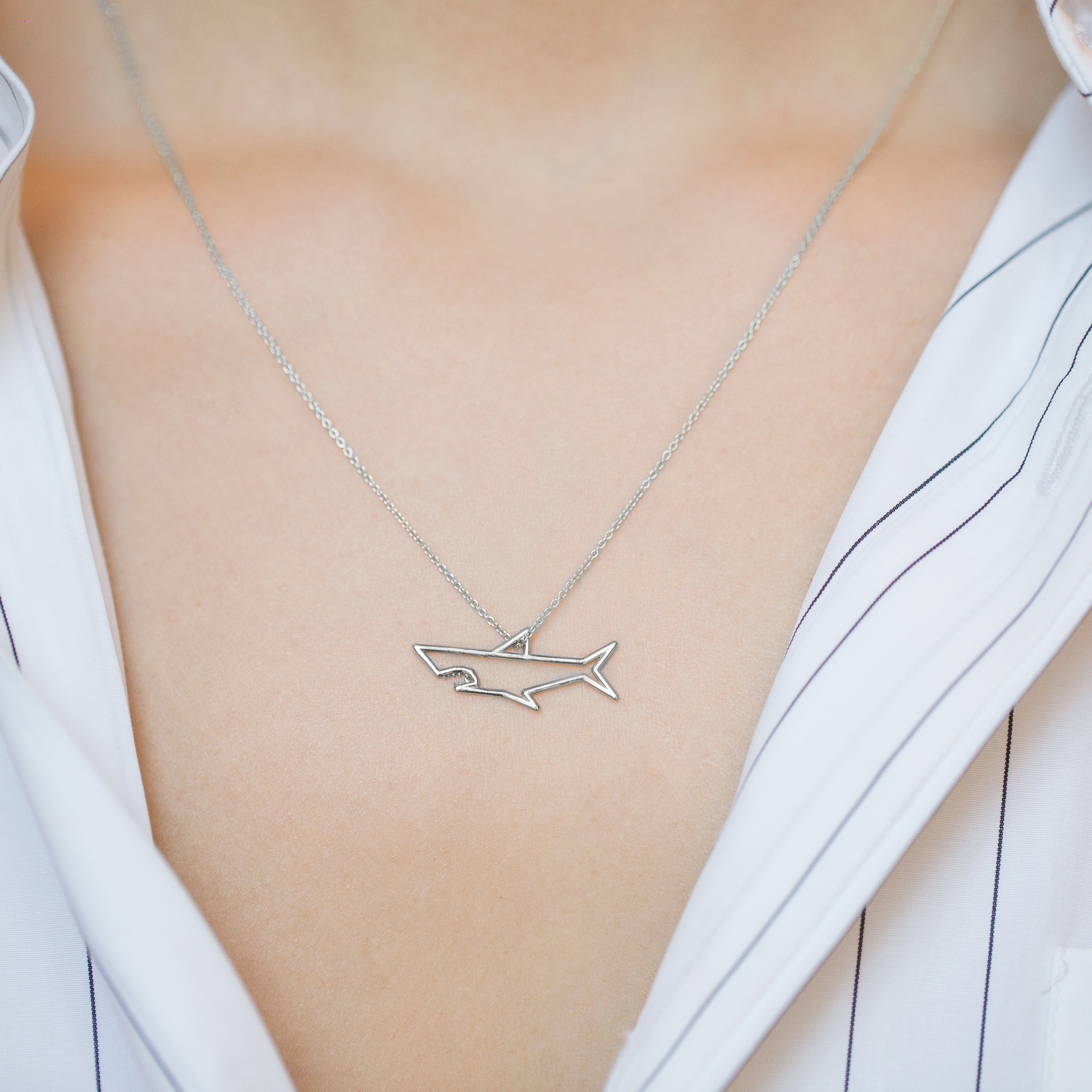 White gold chain necklace with shark shaped pendant worn by model