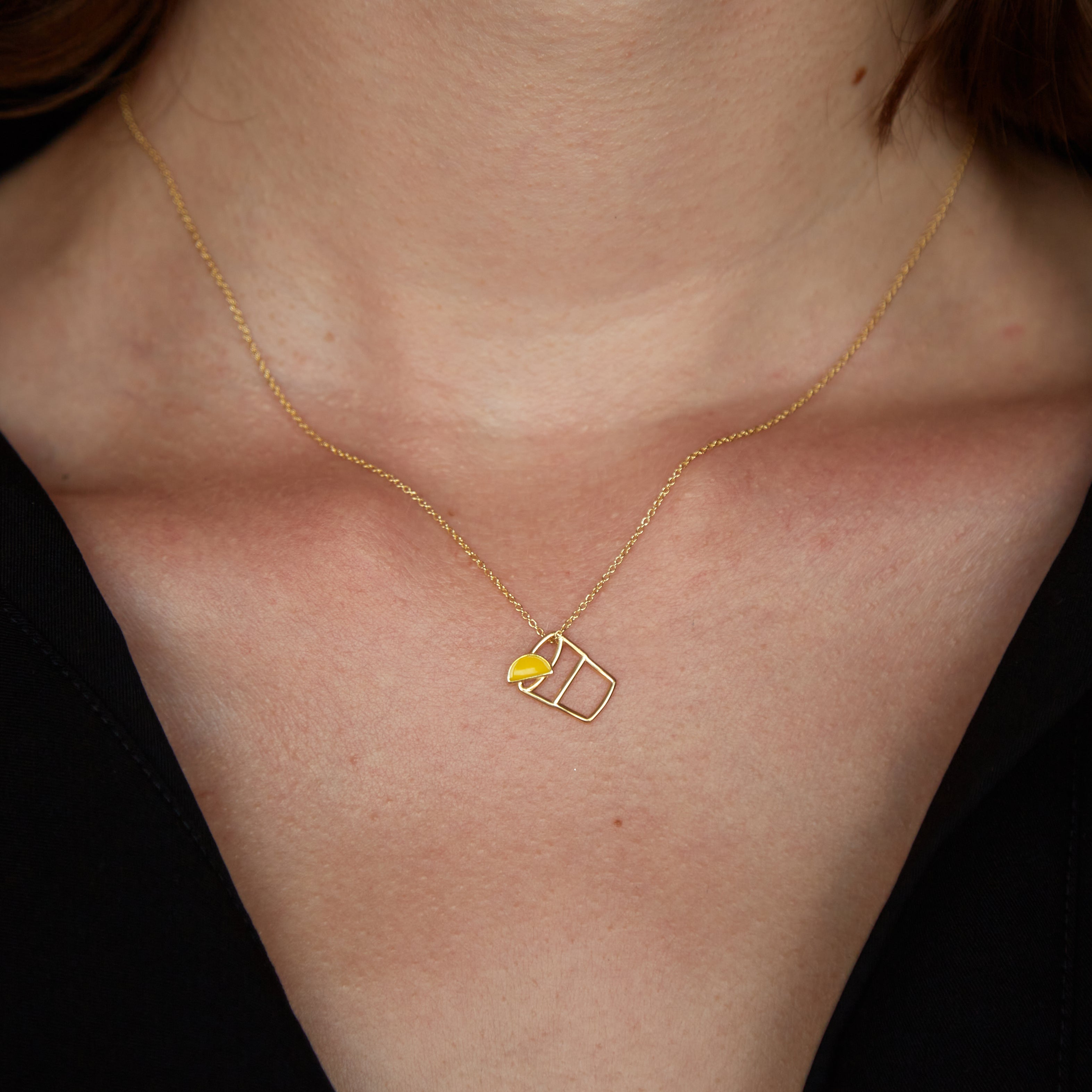 Gold chain necklace with tequila shot shaped pendant worn by model