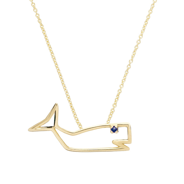 Gold chain necklace with a whale shaped pendant with a blue sapphire as eye