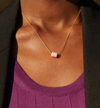 Load image into Gallery viewer, Woman wearing a gold chain necklace with a cylinder pink opal stone
