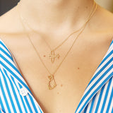 Gold chain necklaces with airplane and cat shaped pendants worn by model