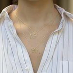 Gold chain necklace with dog shaped pendant and small diamond worn by model